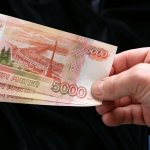 man holding large bills in his hand