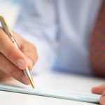 Мужская рука подписывает документ